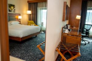a hotel room with a bedroom with a bed and a desk at Hilton Garden Inn Nairobi Airport in Nairobi