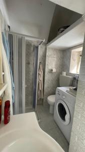 a bathroom with a toilet and a washing machine at Dimora Marina sul Gargano in Vieste
