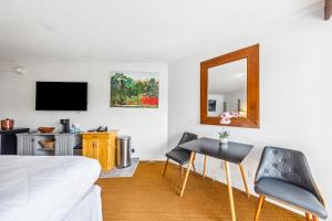 a bedroom with a bed and a table and a mirror at 2417 at Oceanfront Resort Lihue Kauai Beach Drive Private Condo in Lihue