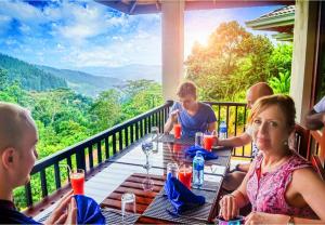 a group of people sitting at a table on a balcony at Grand Hills kandy in Kandy