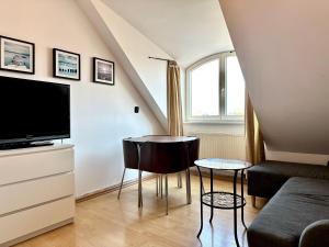 a living room with a couch and a tv and a table at Pokoje Monte 49 in Sopot