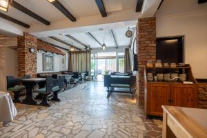 a dining room with tables and chairs and a brick wall at Villa Piccolotti in Neum