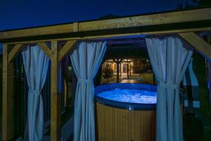 a soak in a hot tub in a backyard at night at Krasowa Ostoya in Kusięta