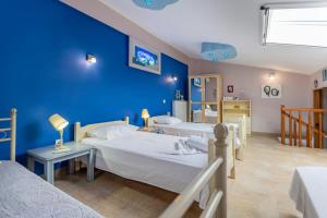 een kamer met twee bedden en een blauwe muur bij Sofia's Villa in Nikiti +47 foto's