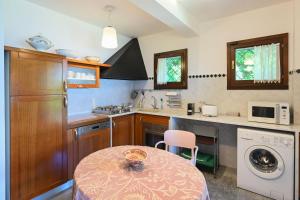 a kitchen with a table and a washing machine at Villa Gia in Someraro +22 photos