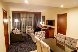 a hotel room with a dining table and a living room at Hilton Garden Inn Nairobi Airport in Nairobi