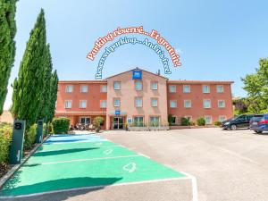 a hotel with a golf course in front of a building at ibis Budget Millau Viaduc in Millau