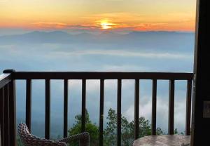 een balkon met een tafel en uitzicht op de bergen bij Grand Hills kandy in Kandy