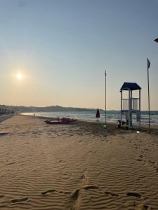 a person standing on a beach with a lifeguard station at Dimora Marina sul Gargano in Vieste