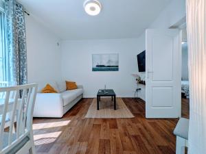 a living room with a white couch and a table at Comfort et Style, Paris Stade de France in Saint-Denis +6 photos