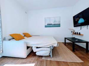 a white bedroom with a bed and a couch at Comfort et Style, Paris Stade de France in Saint-Denis