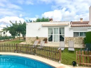 a house with a fence and a swimming pool at Chalet Eucaliptus in Alcossebre