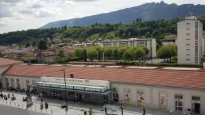 ein großes Gebäude mit rotem Dach in einer Stadt in der Unterkunft Hotel De La Gare in Aix-les-Bains