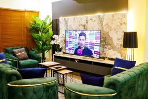 a waiting room with green chairs and a screen at Bawuah Royal Apartments in Kasi