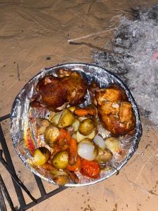 a chicken and vegetables in a pan on a table at وادي رم إبوفيصل in Wadi Rum