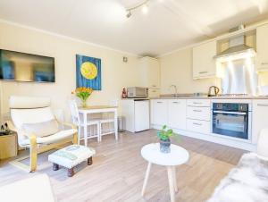 a living room with a kitchen and a table at Willow Lodge in Bosham