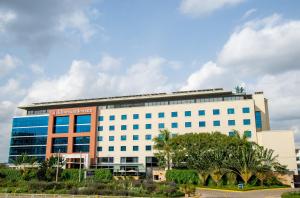 a large white building with trees in front of it at Hilton Garden Inn Nairobi Airport in Nairobi