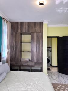 a bedroom with a bed with a wooden wall at Arana Royal Homes in Kampala