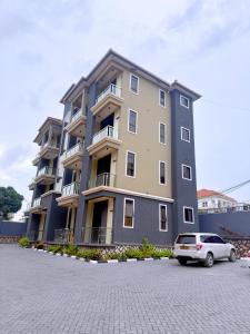 a large building with a car parked in front of it at Arana Royal Homes in Kampala
