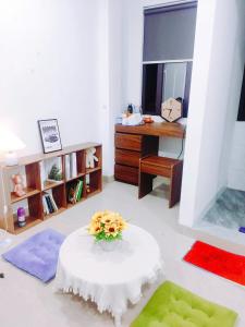 a living room with a table with flowers on it at Heart Homestay in Hanoi +24 photos