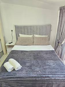 a bedroom with a large bed with two pillows at Grey Studio in Chişinău