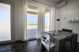 a dining room with a table and a large window at Plemmirio Marèa in Plemmirio