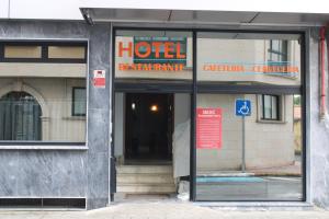 a hotel entrance with a sign in the window at Hotel Villa de Ares in Ares