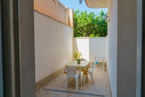 a small balcony with a table and chairs on a patio at Boulevard Holiday in Avola