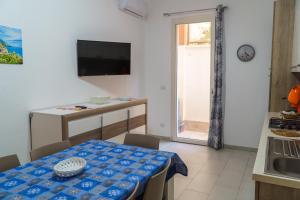 a kitchen and dining room with a table and a television at Boulevard Holiday in Avola