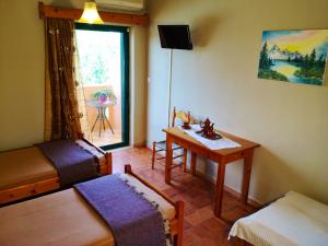 a room with a bed and a table and a window at Chrissas Apartments in Rethymno