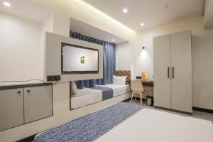 a hotel room with a bed and a desk at Rich Hotel in Mumbai
