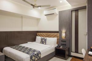 a hotel room with a bed and a television at Rich Hotel in Mumbai