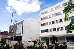 a white building with a sign on the side of it at Omena Hotel Jyväskylä in Jyväskylä