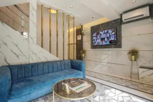a living room with a blue couch and a table at Rich Hotel in Mumbai