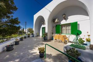 a patio with a table and potted plants on a building at Amoni House- An authentic village stay in Pyrgos