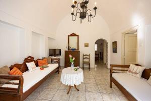 a living room with two couches and a table at Amoni House- An authentic village stay in Pyrgos