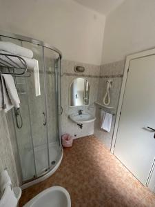 ein Badezimmer mit Dusche, Toilette und Waschbecken in der Unterkunft Hotel Fiorenza in Milano Marittima + 76 Fotos
