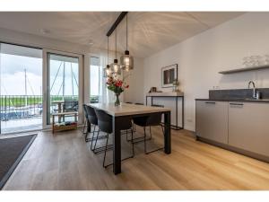 a kitchen and dining room with a table with chairs at Beautiful apartment with beautiful views of the lively marina in Kamperland