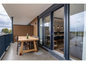a balcony with a wooden table and a dining room at Beautiful apartment with beautiful views of the lively marina in Kamperland