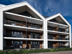 an external view of a white apartment building at Beautiful apartment with beautiful views of the lively marina in Kamperland