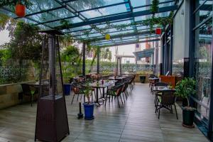 an outdoor patio with tables and chairs and plants at Hilton Garden Inn Nairobi Airport in Nairobi