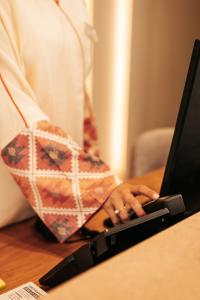a woman with her hand on a laptop computer at Sagredo Boutique Hotel & Spa in Ágios Fokás
