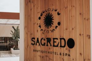 a sign on the side of a wooden wall at Sagredo Boutique Hotel & Spa in Ágios Fokás