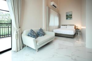 a living room with a bed and a couch and a chair at Khunnapat Pool Villa Khaoyai in Mu Si +28 photos