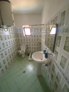 a white bathroom with a sink and a toilet at Vila Demiraj Ksamil Sarande in Ksamil +26 photos