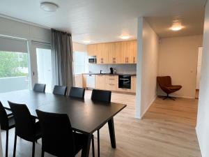 a dining room and kitchen with a table and chairs at Eiðar - Apartments in Eiðar