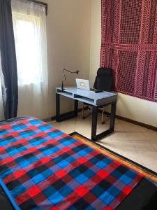 a desk with a laptop on top of a rug at Casa Holmes in Kampala