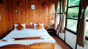a bedroom with a bed in a wooden wall at Kalimpong Bungalow in Kalimpong