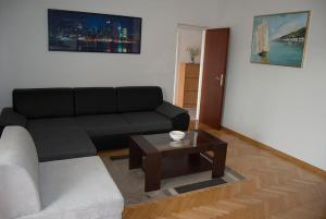 a living room with a black couch and a coffee table at Moretino Supetar in Supetar