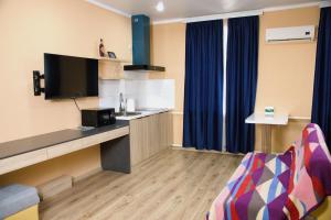 a room with a desk with a tv and a couch at Travel Point hotel in Bishkek